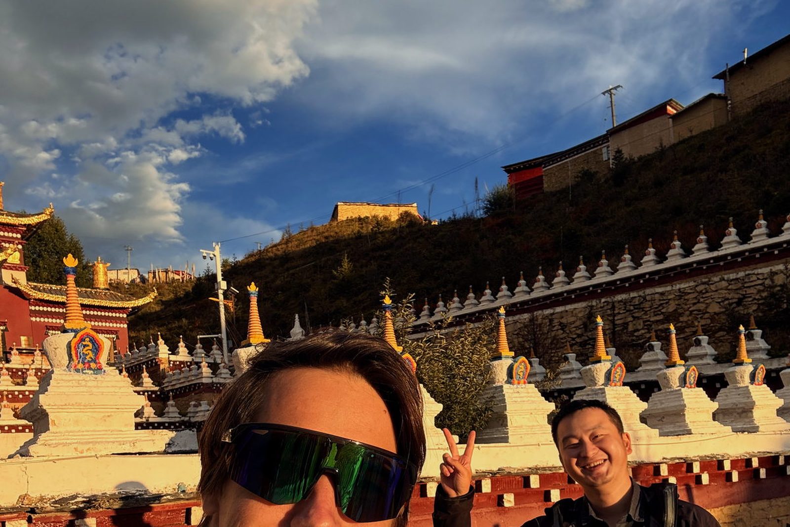 TK with guests on the road, monastery roofs behind