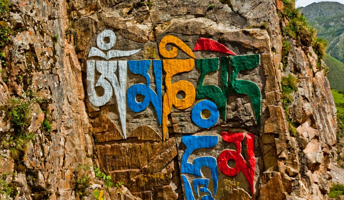 The six-syllable mantra carved into a rock face and painted white, blue, yellow, green and red