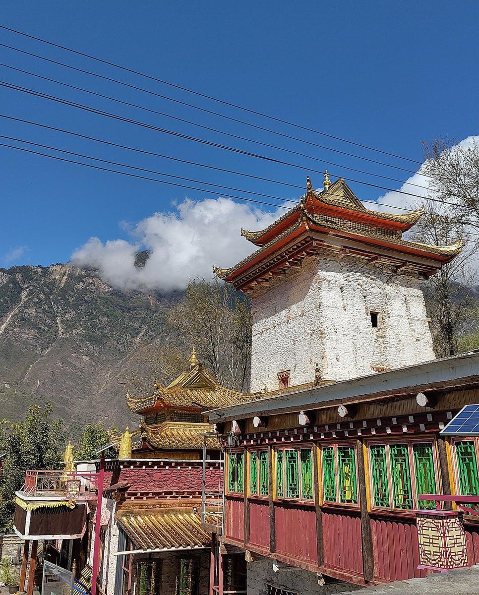 The white tower-house and gilded roofs of the temple at Jikayi, Zhonglu